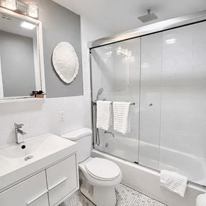 Brooklyn apartment for rent - A white bathroom with a toilet, sink, and shower.