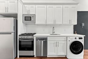 Brooklyn apartment for rent - A white kitchen with a stainless steel refrigerator, oven, dishwasher, and washing machine.