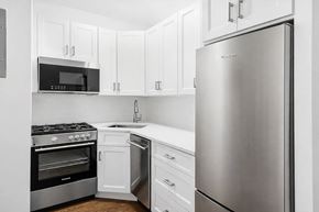 Brooklyn apartment for rent - A kitchen with a stainless steel refrigerator, oven, and microwave.