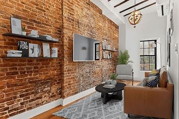 Brooklyn apartment for rent - A living room with a brick wall and a brown couch.