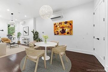 Brooklyn apartment for rent - A dining room with a white table and chairs, a chandelier, and a painting on the wall.