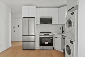Brooklyn apartment for rent - A modern kitchen with stainless steel appliances and white cabinets.