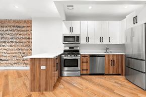 Brooklyn apartment for rent - A modern kitchen with wooden cabinets and stainless steel appliances.
