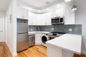 Brooklyn apartment for rent - A kitchen with white cabinets and a stainless steel refrigerator.