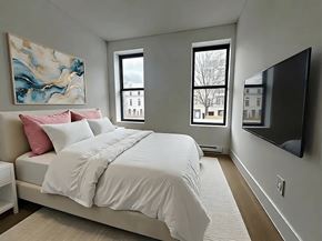 Brooklyn apartment for rent - A bedroom with a large bed and a painting on the wall.