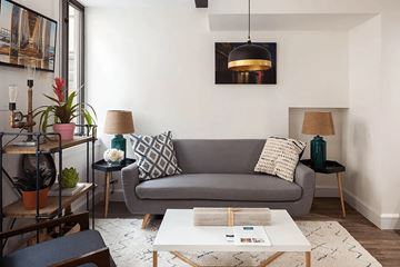 Brooklyn apartment for rent - A living room with a grey couch, a white coffee table, and a black side table with a lamp.