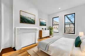 Brooklyn apartment for rent - A bedroom with a large bed and a fireplace.