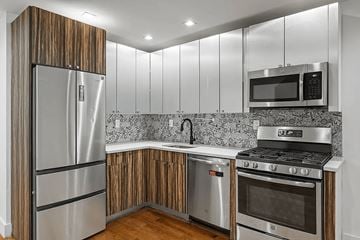 Brooklyn apartment for rent - A modern kitchen with a stainless steel refrigerator, microwave, and oven.