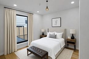 Brooklyn apartment for rent - A bedroom with a large bed, a balcony with a view of a pool, and a framed picture on the wall.
