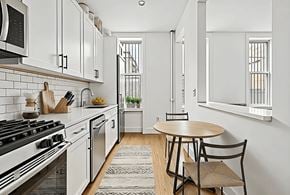Brooklyn apartment for rent - A kitchen with a stove, oven, and a table with two chairs.