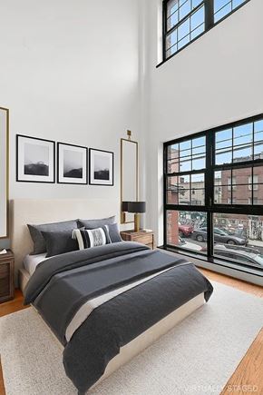 Brooklyn apartment for rent - A bedroom with a large bed and a window overlooking a city street.