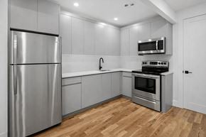 Brooklyn apartment for rent - A modern kitchen with a stainless steel refrigerator and wooden flooring.
