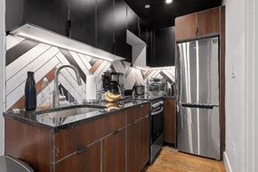 Brooklyn apartment for rent - A kitchen with a black counter top and wooden cabinets.