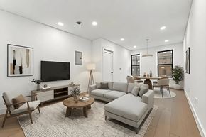 Brooklyn apartment for rent - A modern living room with a grey sofa, wooden coffee table, and a flat screen TV.
