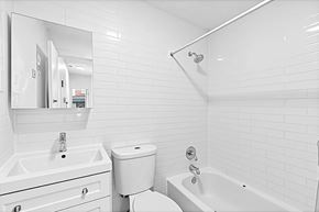 Brooklyn apartment for rent - A white bathroom with a sink, toilet, and bathtub.