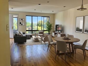 New York apartment for rent - A modern living room with a large window and a dining table set for four.