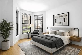 Brooklyn apartment for rent - A bedroom with a large bed, a chair, and a potted plant.
