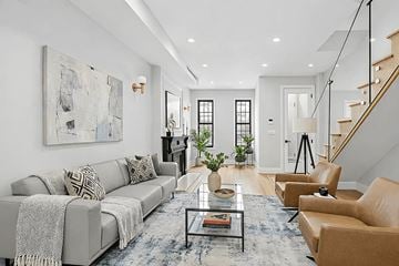 Brooklyn triplex for rent - A living room with a grey couch, a coffee table, and a painting on the wall.