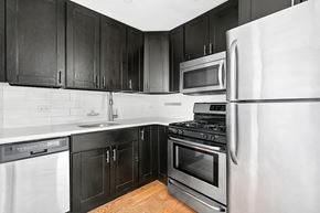 Brooklyn apartment for rent - A kitchen with black cabinets and stainless steel appliances.