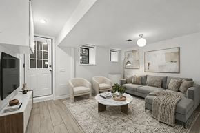 Brooklyn apartment for rent - A living room with a grey couch, a coffee table, and a television.