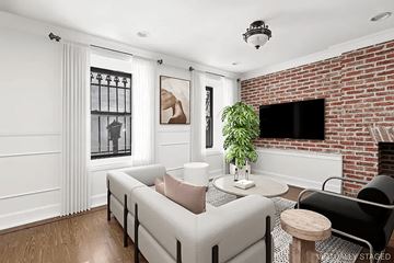 Brooklyn apartment for rent - A living room with a white couch and a brick fireplace.