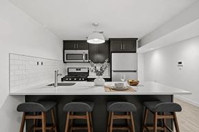 Brooklyn apartment for rent - A modern kitchen with a white countertop and grey bar stools.