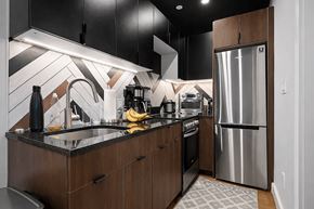 Brooklyn apartment for rent - A modern kitchen with a black and white tiled backsplash.