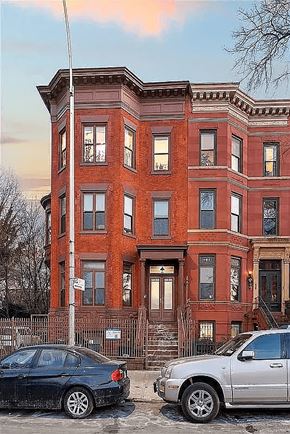 Brooklyn apartment for rent - Two cars parked in front of a red brick building.