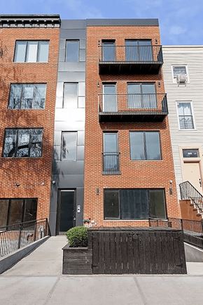 Brooklyn apartment for rent - A red brick building with a black door and windows.