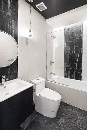 Brooklyn apartment for rent - A black and white bathroom with a toilet, sink, and shower.