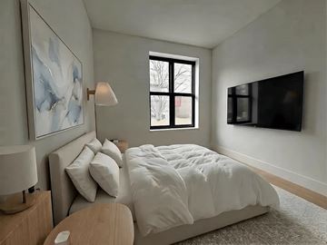 Brooklyn apartment for rent - A bedroom with a large bed and a painting on the wall.