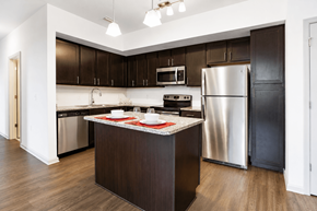 Spring Hill apartment for rent - A kitchen with dark brown cabinets and a stainless steel refrigerator.