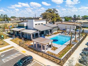 Tallahassee apartment for rent - an aerial view of a building with a pool in the foreground and a parking lot in the