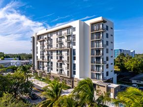 Aventura apartment for rent - A modern apartment building with balconies and surrounded by greenery.