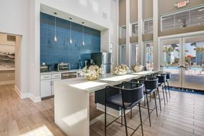 Cocoa apartment for rent - A kitchen with a table and chairs in front of a blue backsplash.