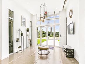 Miami apartment for rent - the living room has large glass doors and a chandelier