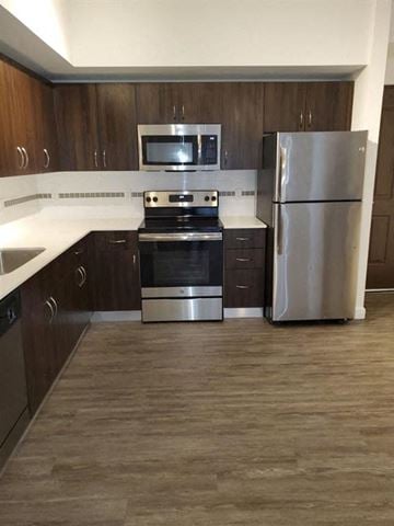 Miami apartment for rent - a kitchen with stainless steel appliances and wooden cabinets