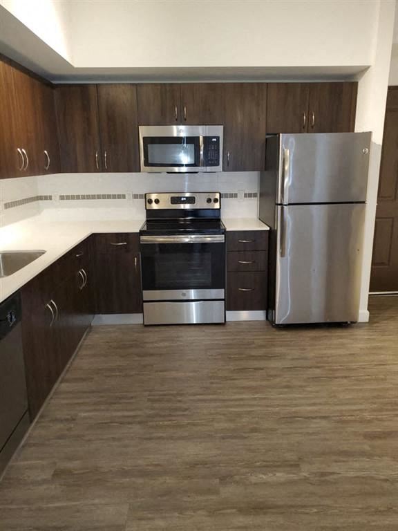 Miami apartment for rent - a kitchen with stainless steel appliances and wooden cabinets