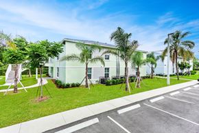 Belle Glade apartment for rent - a large white building with palm trees in front of it