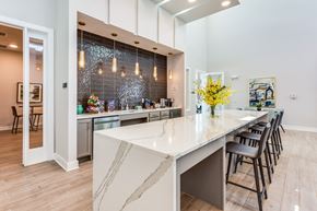 Tallahassee apartment for rent - a kitchen with a large white island with a long countertop and a row of black chairs