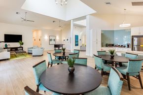 Lakeland apartment for rent - a communal area with tables and chairs and a kitchen in the background