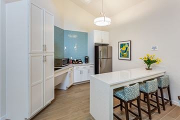 Lakeland apartment for rent - A kitchen with white cabinets and a white island with blue chairs.