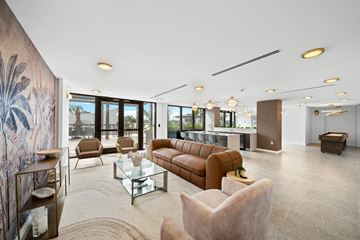 Aventura apartment for rent - A living room with a brown sofa and a glass coffee table.