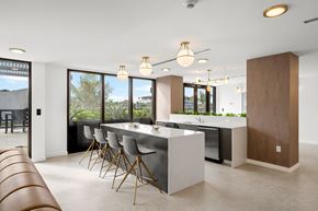 Aventura apartment for rent - A modern kitchen with a long table and chairs.