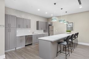 Miami apartment for rent - a kitchen with gray cabinets and a white counter top