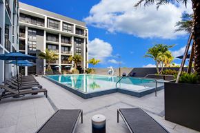 Fort Lauderdale apartment for rent - a large swimming pool with lounge chairs and umbrellas in front of a hotel