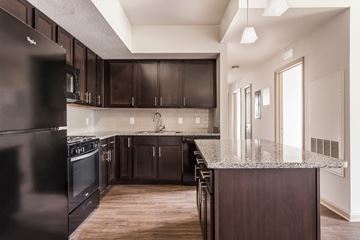 Brooksville apartment for rent - A kitchen with dark wood cabinets and a black refrigerator.