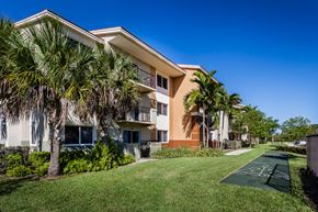 Homestead apartment for rent - a grassy area with trees and buildings in the background