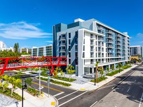 Hollywood apartment for rent - A modern building with a red bridge in front of it.