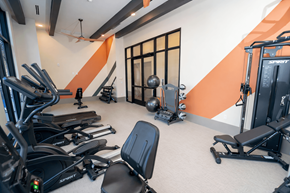 Miami apartment for rent - A gym with orange walls and a variety of exercise equipment.